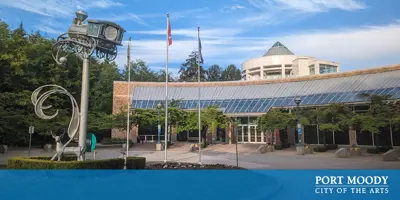 City Hall on a sunny day, with an elevated sculpture of a train, and a deer sculpture in the foreground