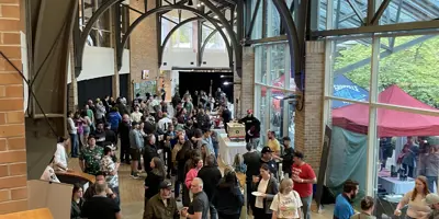 Booths are set up and a crowd moves around the inside of the galleria