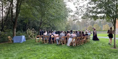 Guests sit for a wedding ceremony as two people walk up the aisle