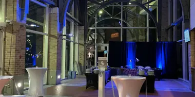 Tables are set up in an atrium with dim lighting