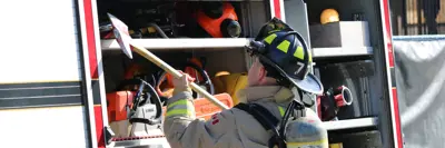 Firefighter Getting Equipment From Truck
