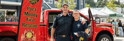 Two firefighters in front of a pick-up truck