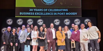 Winners of the Spike Business Awards standing together on a stage with their trophies