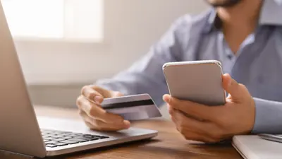 Person holding a phone and using the computer