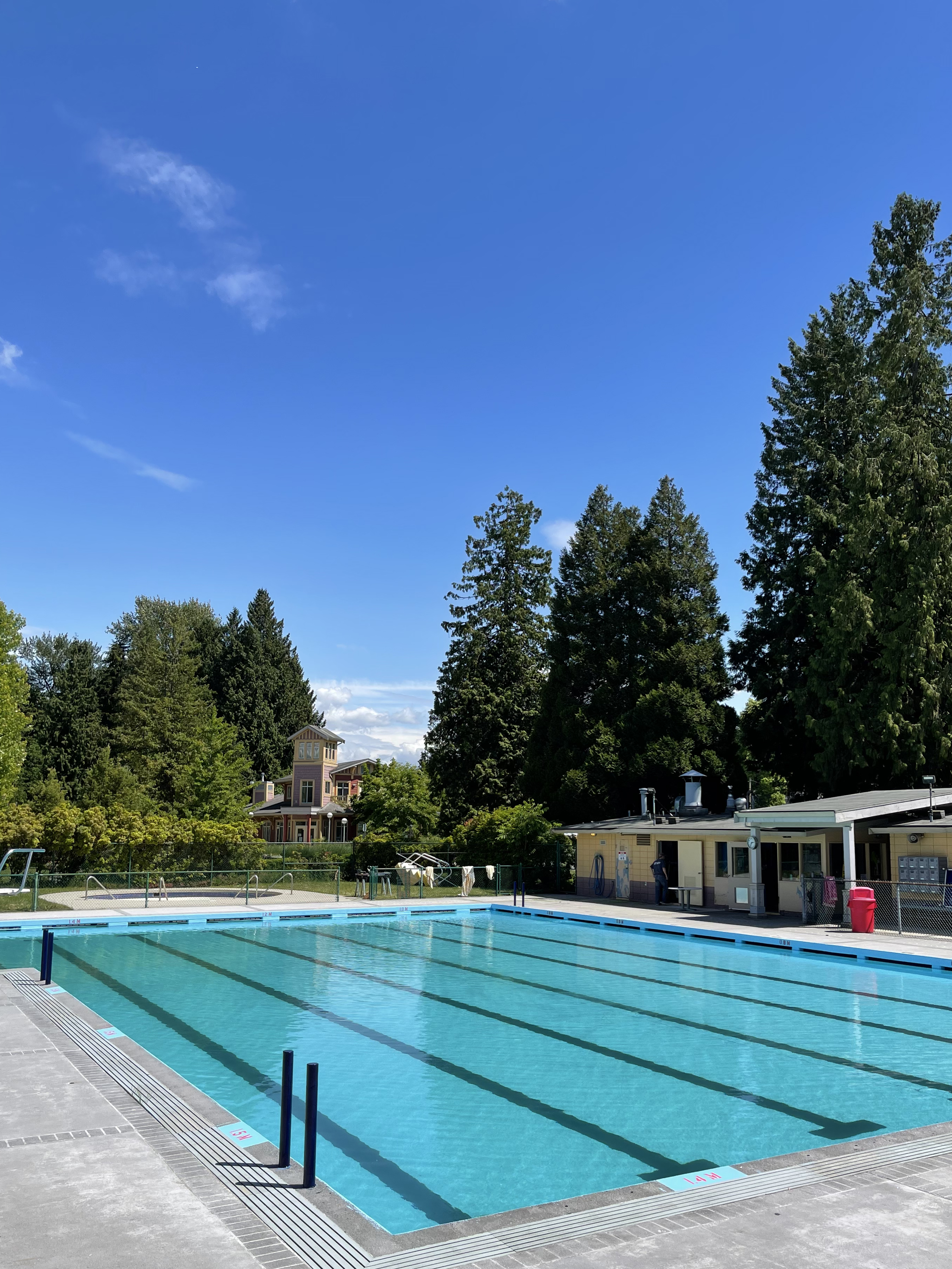 Outdoor pool with pool house and blue skies