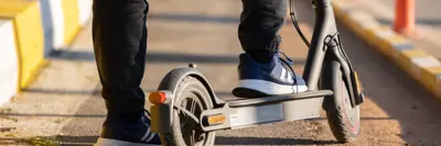 A person stepping onto an e-scooter