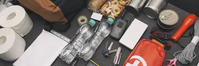 Components of an emergency kit including items like a first aid kit, food, water, toilet paper