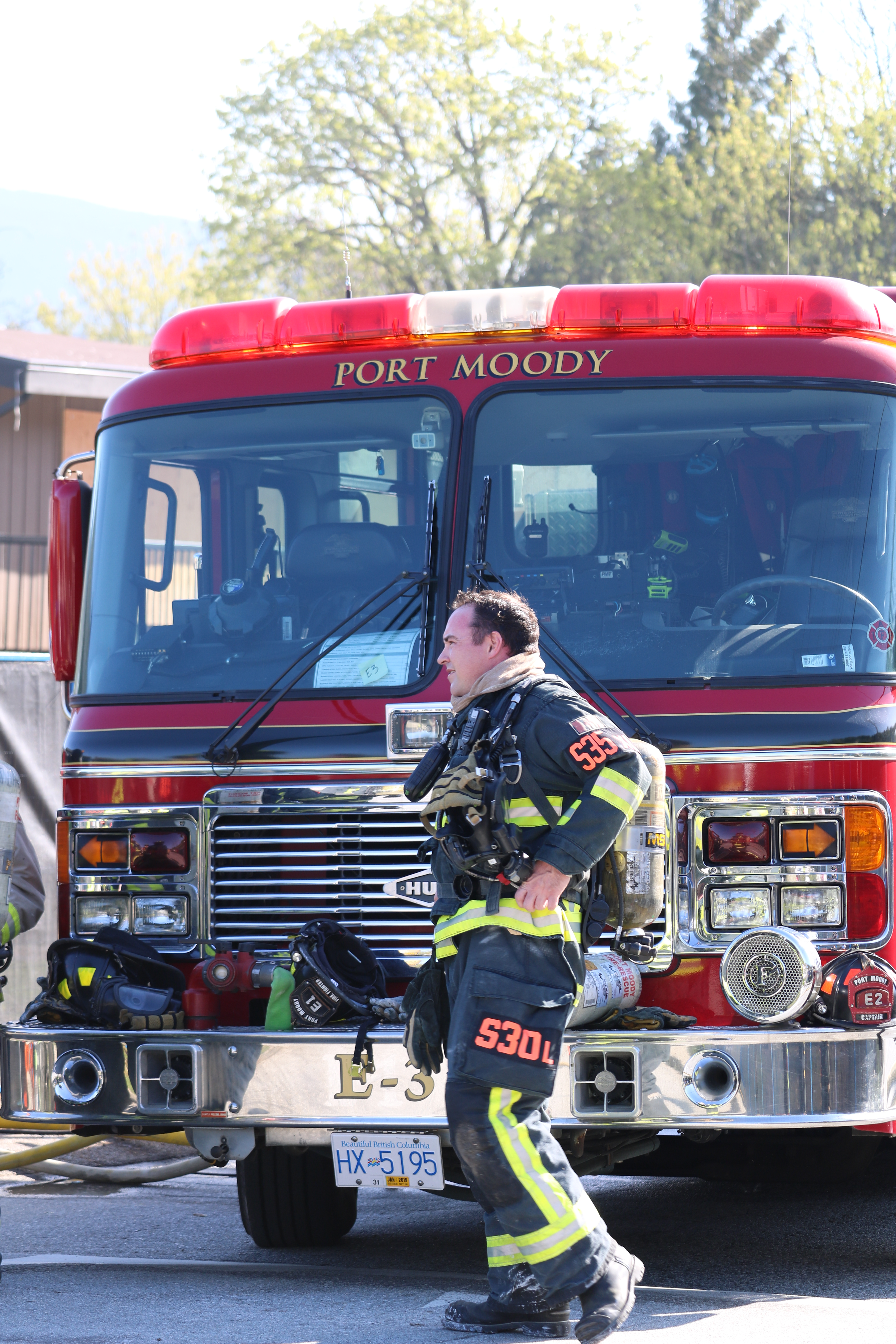 firefighter in gear in front of fire truck