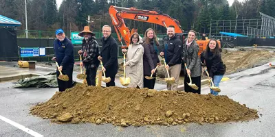 A group of people holding shovels for the first dig at a construction site