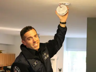 Firefighter inspecting smoke detector