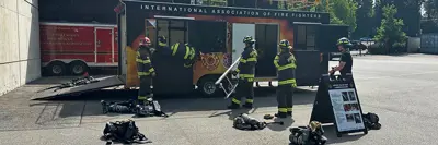 fire fighters setting up training in front of an info trailer