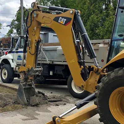 Excavator digging up road