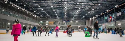 Public skating session at Arena 2 in Port Moody, with a lively crowd of parents and children gliding across the ice under bright arena lights.