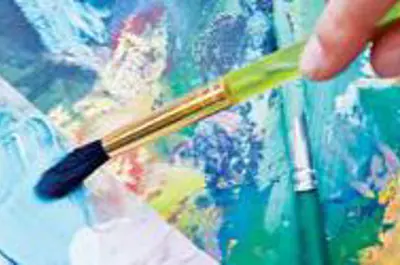 A hand holding a paint brush and painting