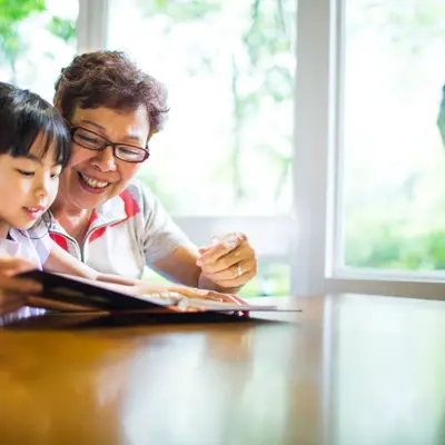 An older adult reading to a young child