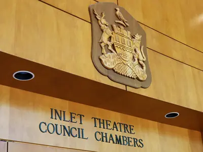 A wooden sign that says Inlet Theater Council Chambers