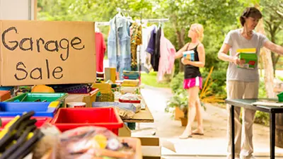 Garage sale set up with people perusing